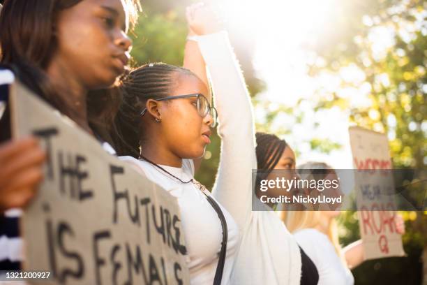 diversas adolescentes cogidas de la mano durante una marcha por los derechos de las mujeres - igualdad de género fotografías e imágenes de stock