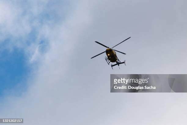 searching police helicopter on patrol - helicóptero fotografías e imágenes de stock