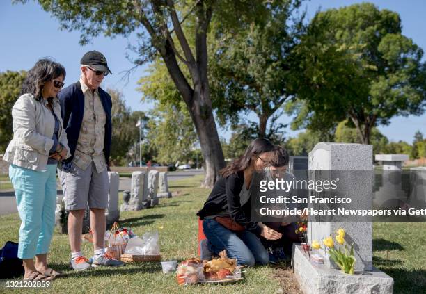 Alice Lai-Bitker and her husband Steve Bitker watch as their daughter Janelle Bitker and her husband Jeremy B. White pour wine out of small cups as...