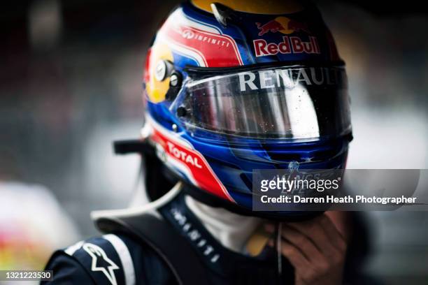 Australian Red Bull Racing Formula One racing driver Mark Webber on the starting grid wearing his crash helmet with a reflective visor while he...