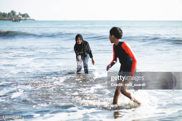 sommerspaß am bali-strand - muslim woman beach stock-fotos und bilder