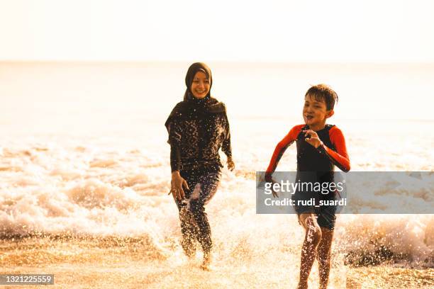 summer fun on the bali beach - islamic action front stock pictures, royalty-free photos & images