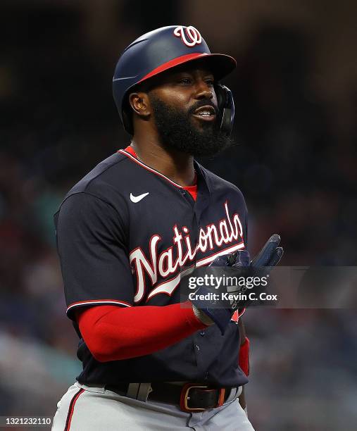 Josh Harrison of the Washington Nationals reacts as he heads to first base after being hit by pitch in the fourth inning by Max Fried of the Atlanta...