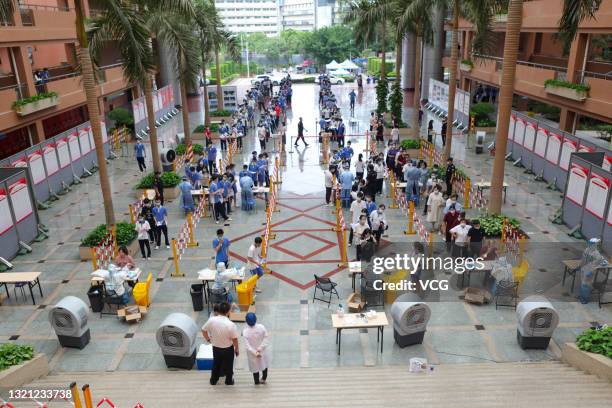 Students and teachers line up for nucleic acid testing at a high school ahead of the National College Entrance Examination, aka Gaokao, on May 31,...