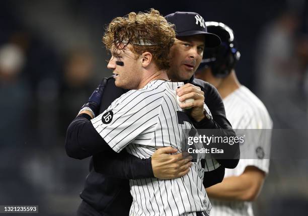 Clint Frazier of the New York Yankees is congratulated by manager Aaron Boone after Frazier hit a two run home run to win the game at Yankee Stadium...