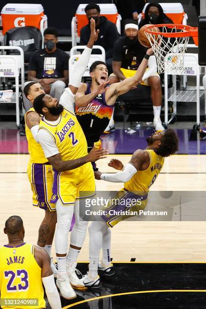 Devin Booker of the Phoenix Suns lays up a shot against Andre Drummond and Wesley Matthews of the Los Angeles Lakers during the second half in Game...