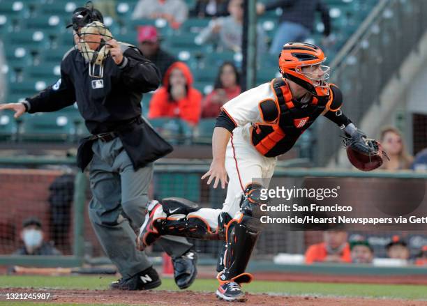 Buster Posey scrambles after a wild pitch by Alex Wood that scored Andrew Heaney in the third inning as the San Francisco Giants played the Los...