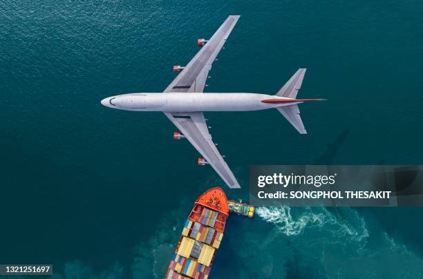 passenger planes flying over the sea with cargo ships sailing on the sea. - air freight transportation stock pictures, royalty-free photos & images