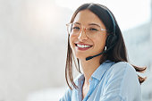 Shot of an attractive young saleswoman sitting alone in the office and wearing a headset