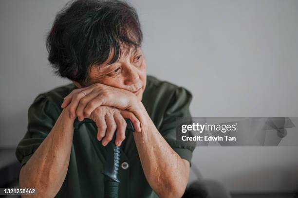 triste asiática mujer mayor china en casa retrato - soledad fotografías e imágenes de stock