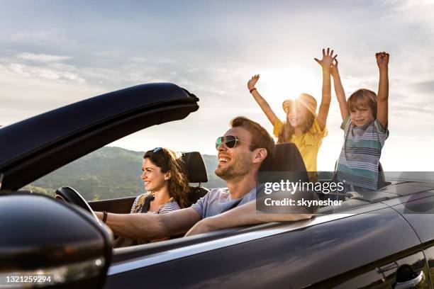 carefree family having fun during road trip by convertible car. - convertible stock pictures, royalty-free photos & images