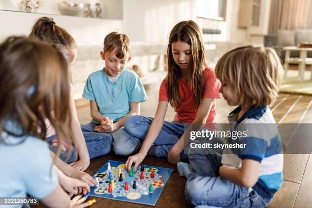 groupe d’enfants jouant au jeu de ludo dans le salon. - board game photos et images de collection