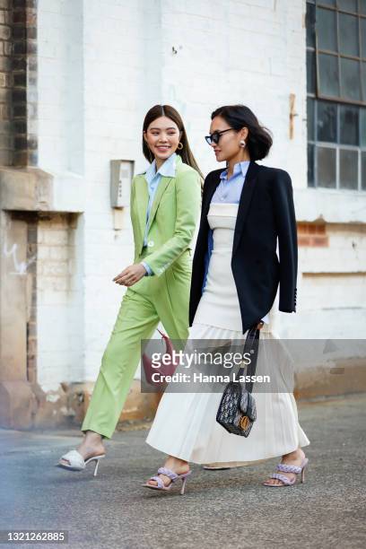 Jolie Nguyen wearing Nudie Eye green cropped suit, Prada pink bag and Bottega Veneta shoes and Christine Ai wearing Dion Lee dress, Tom Ford shirt,...