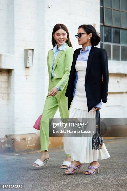 Jolie Nguyen wearing Nudie Eye green cropped suit, Prada pink bag and Bottega Veneta shoes and Christine Ai wearing Dion Lee dress, Tom Ford shirt,...