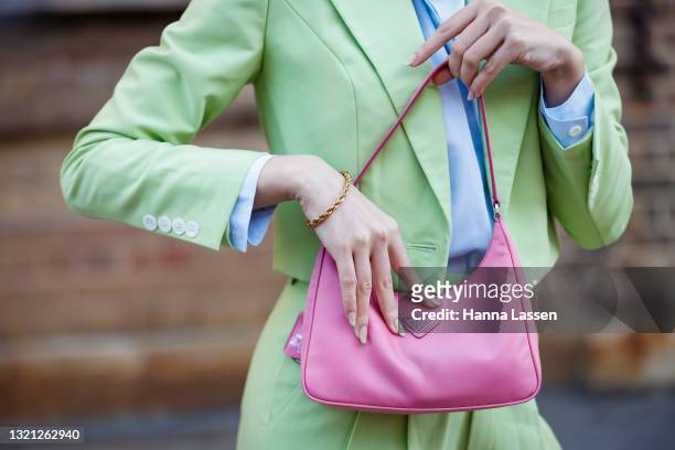 Jolie Nguyen, bag detail, wearing Nudie Eye green cropped suit, Prada pink bag and Bottega Veneta shoes at Afterpay Australian Fashion Week 2021 on...