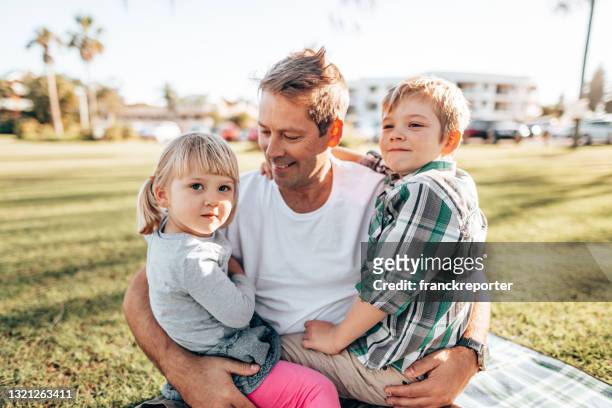 father playing with sons in the courtyard - public park photos stock pictures, royalty-free photos & images