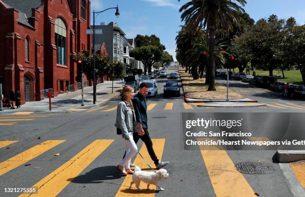 Julia and Jack Altman walk with their rescue dog Teddy in Dolores Park near their home in the Mission District of San Francisco, Calif., on Sunday,...