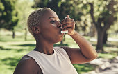 Shot of a young woman taking a break during a workout to use her asthma pump
