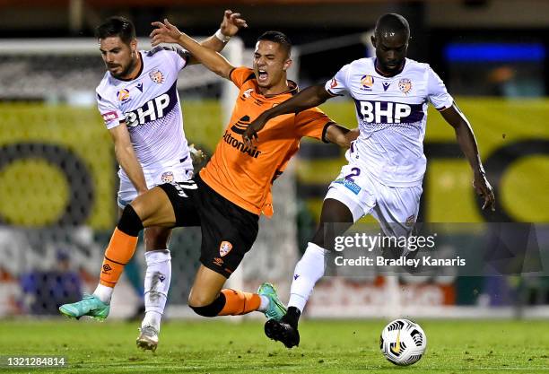 Joe Champness of the Roar is pressured by the defence of Jason Geria and Bruno Fornaroli of the Glory during the A-League match between the Brisbane...