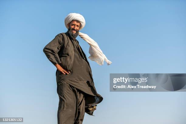 a pashtun nomad wearing traditional dress looks out over his flock near herat - afghanistan dress stockfoto's en -beelden