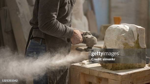 steinmetz, der mit kreissägend einen stein schneidet - block of marble stock-fotos und bilder