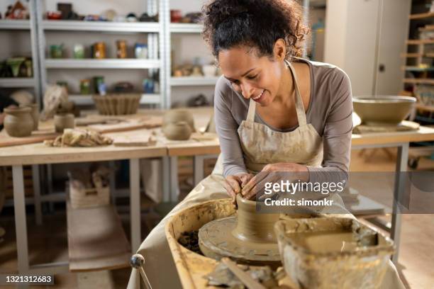 potier femelle fabriquant un vase en céramique sur une roue de potier - pottery wheel photos et images de collection
