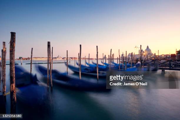 Venetian gondola on canal in Venice at sunset, Italy
