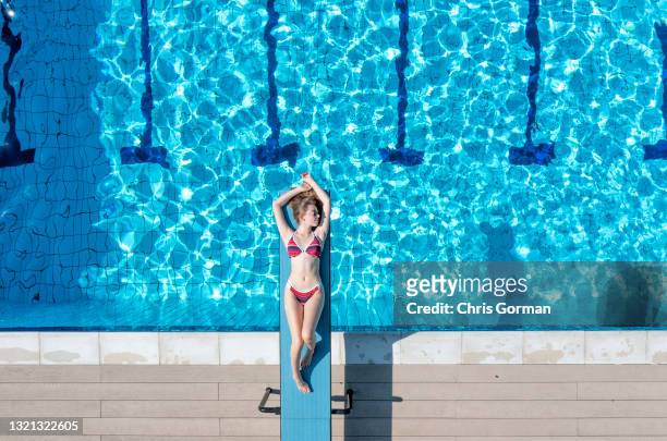 An aerial view of sunbather Eleanor Jacob posing for a portrait at Petersfield Open Air Pool on May 31,2021 in Petersfield, United Kingdom.
