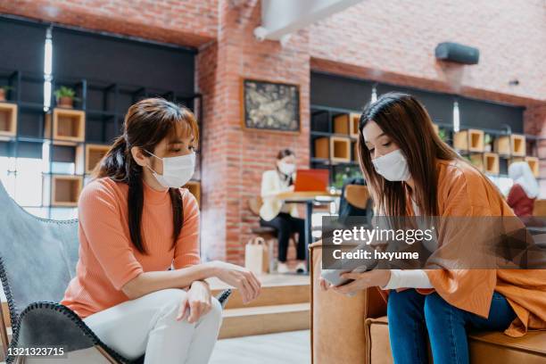 young businesswomen with protective face mask working in co-working space - reopening ceremony stock pictures, royalty-free photos & images