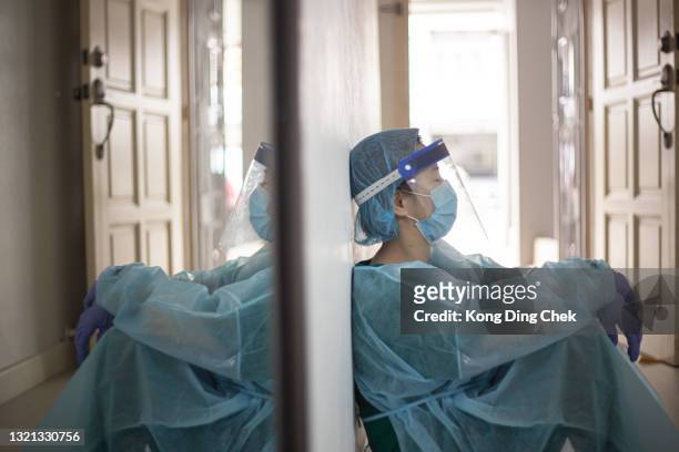 aziatische chinese vrouwelijke front liner vermoeide zitting op vloer tijdens pandemie - pandemic illness stockfoto's en -beelden