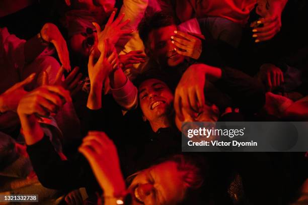 beautiful young people lie around in the red light - miembro fotografías e imágenes de stock