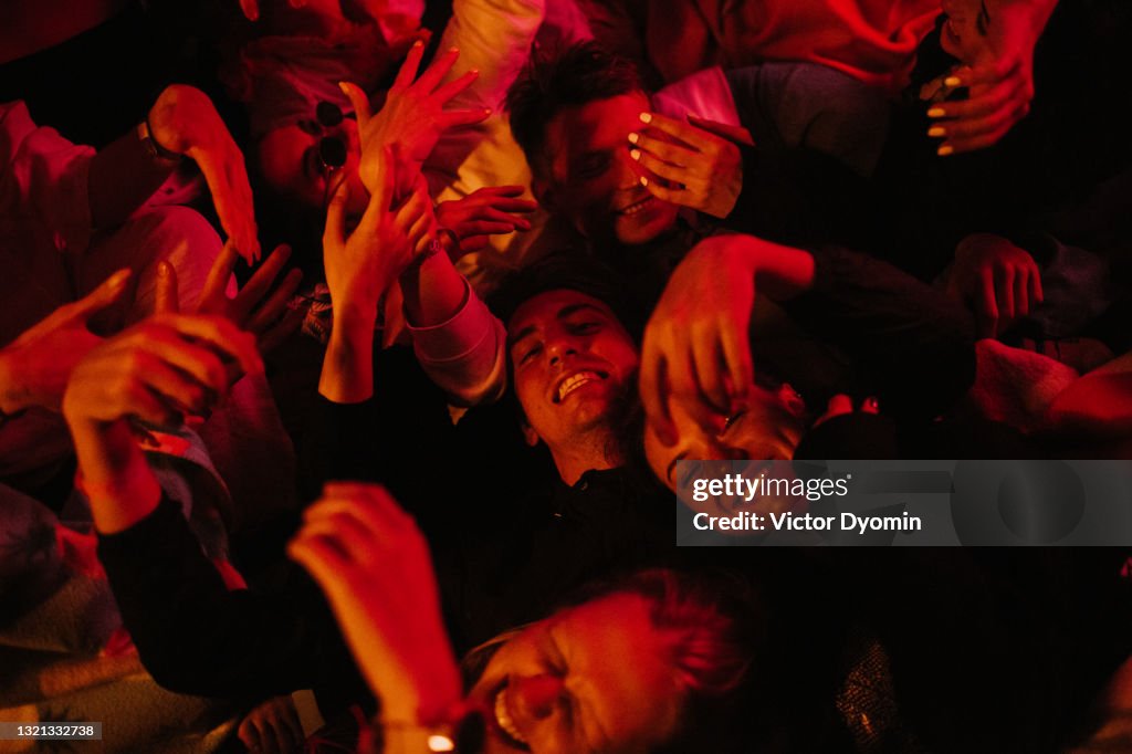 Beautiful young people lie around in the red light