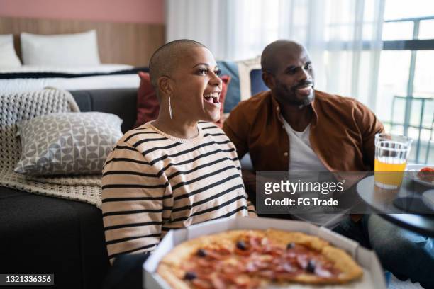 mature couple eating pizza and watching tv at home - mood stream stock pictures, royalty-free photos & images