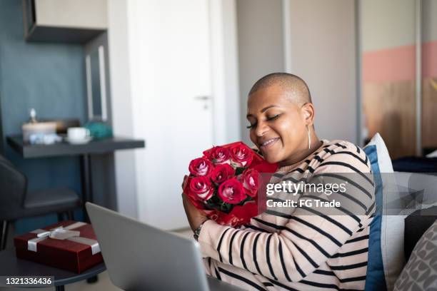 mature woman receiving roses from boyfriend during video call at home - covid dating stock pictures, royalty-free photos & images