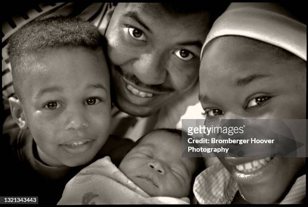 Portrait of an unidentified couple as they pose with their son and newborn baby, Bellevue, Washington, 1992.