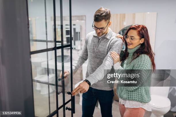 young couple making decision which shower will set perfectly in their new home - new bathroom stock pictures, royalty-free photos & images
