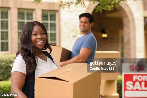 la pareja joven emocionada mueve cajas a su nuevo hogar. - family in front of home fotografías e imágenes de stock