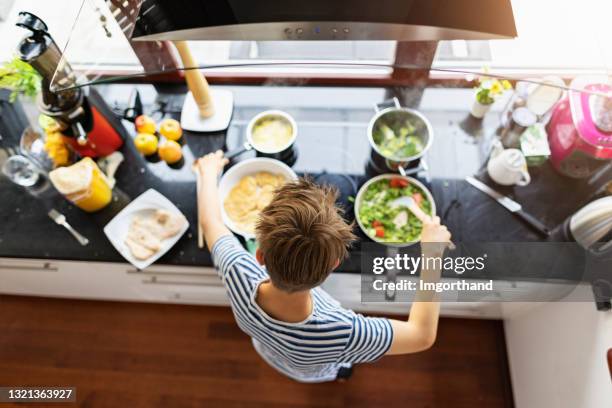 teenage boy helping to prepare meal for family - boy cooking stock pictures, royalty-free photos & images