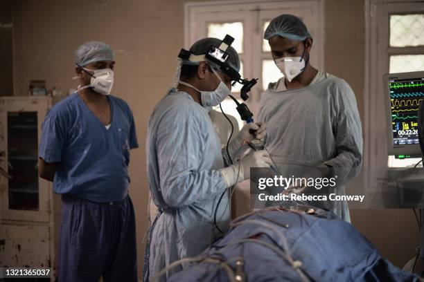 Members of an Indian surgical team perform an endoscopic surgery to remove a fungal infection from a patient suffering from mucormycosis at the...