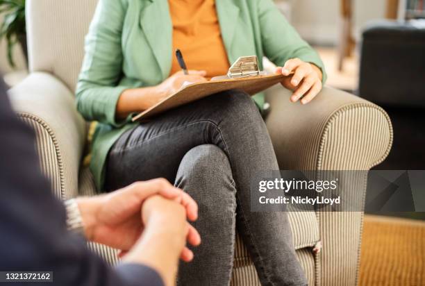 mental health professional taking notes during a counseling session - psychotherapist stock pictures, royalty-free photos & images