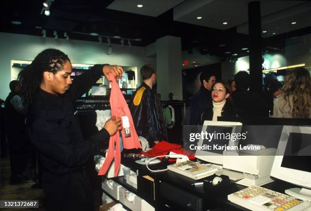 Swedish retailer H&M opens its third store in Manhattan on Lower Broadway. A cashier checks out a customer at an opening night event on March 22 in...
