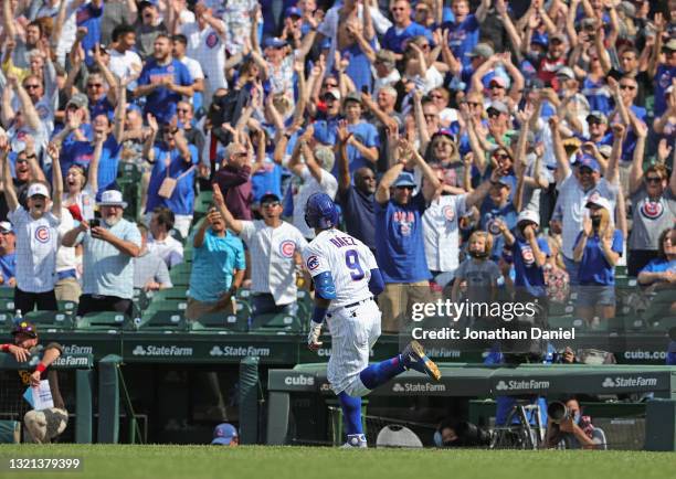 Fans cheer as Javier Baez of the Chicago Cubs runs the bases after hitting two run home run in the 7th inning against the San Diego Padres at Wrigley...