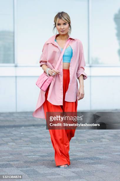 Influencer Gitta Banko wearing a light pink oversize blouse by Gitta Banko, a aqua blue wool and silk bralette by Boscana, red marlene pants by...