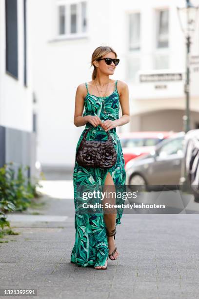 Influencer Gitta Banko wearing a long summer dress with green floral print and high leg slit by Boscana, python wrap sandals by Bottega Veneta, a...