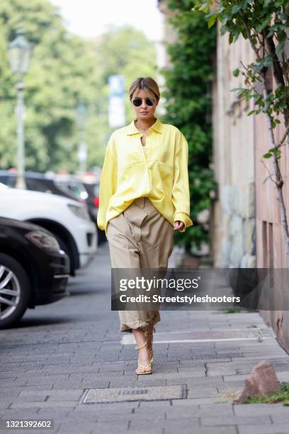 Influencer Gitta Banko wearing a yellow oversize blouse by Boscana, beige double waist pants by Burberry, yellow sandals by Bottega Veneta,...