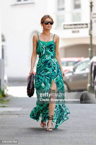 Influencer Gitta Banko wearing a long summer dress with green floral print and high leg slit by Boscana, python wrap sandals by Bottega Veneta, a...