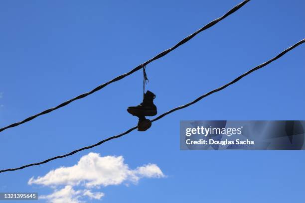 shoes hanging from an overhead power line - bound in high heels stock pictures, royalty-free photos & images