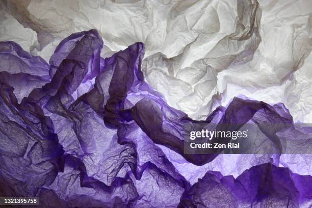 backlit creased tissue wrapping paper in purple, black and white - papel de seda fotografías e imágenes de stock