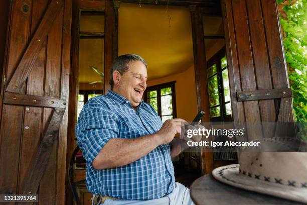 smiling farmer using smartphone - fat farmer stock pictures, royalty-free photos & images