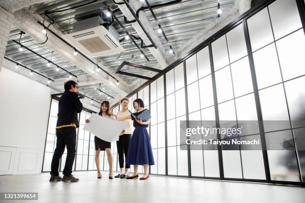 new business members discussing the blueprints in the new office - asian ceiling stock-fotos und bilder